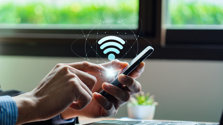 A man on a phone with a Wi-Fi icon floating above it
