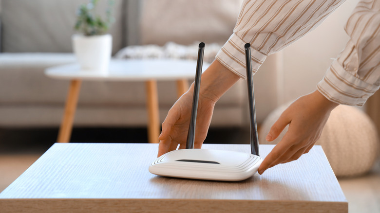 A man placing a router on a table