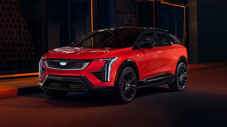 A red Cadillac Optiq parked along a city street