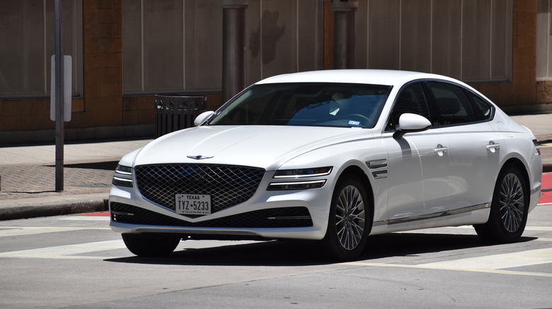 Genesis G80 in white cruising down Texas street.
