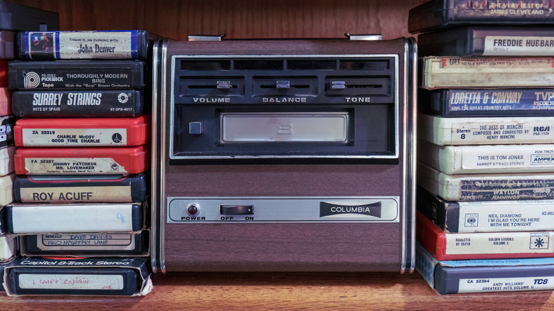 An 8-track player surrounded by 8-track cartridges