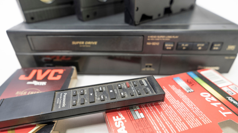 A VCR with remote control and VHS tapes