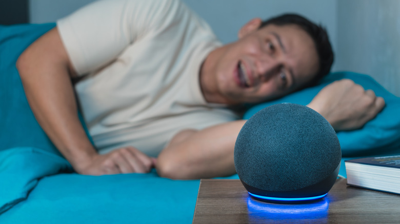 A man giving a voice command to an Echo Dot.