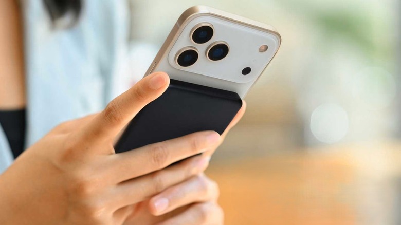 iHome 5000mAh Magnetic Power Bank attached to back of phone while held in hand