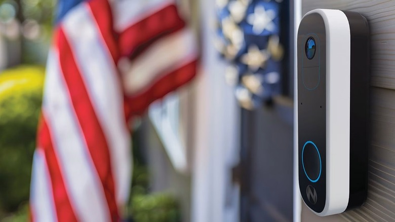 Night Owl 2K Video Doorbell attached to front of home next to door and flag