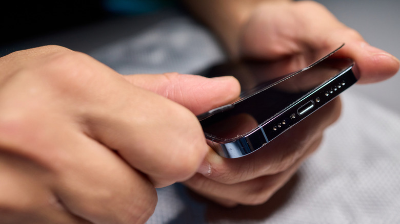 Hands applying screen protector to smartphone