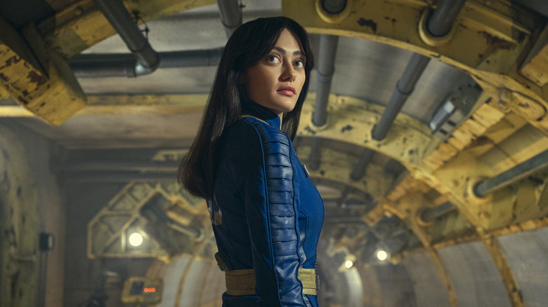 Lucy standing inside her vault, smiling, in "Fallout."