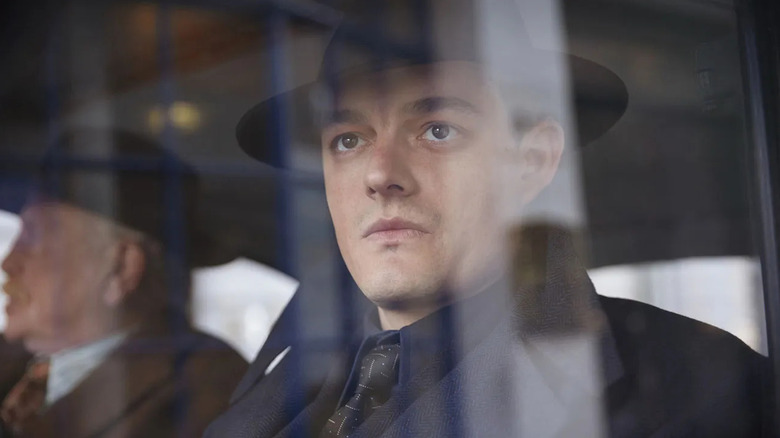 Detective Superintendent Douglas Archer frowning while sitting in a car in "SS-GB."