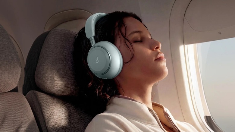 A woman wearing Soundcore headphones on a plane