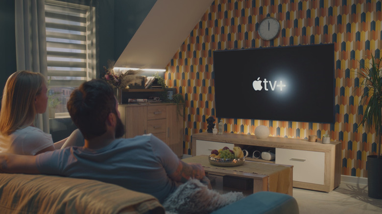 A couple staring at an Apple TV