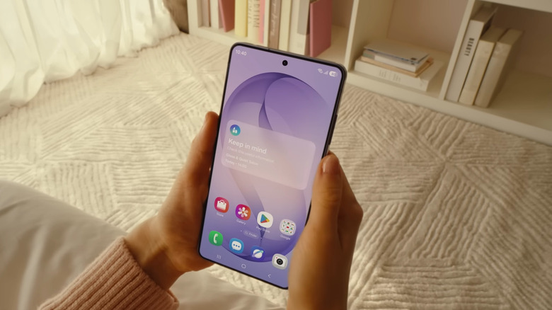 Hands holding Samsung Galaxy S26 showing home screen with Galaxy apps