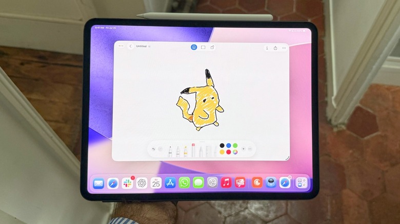A hand holding an iPad Pro with the Paper app opened up