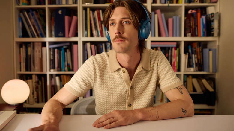 Man using Bose QuietComfort SC Noise Canceling Headphones while using computer