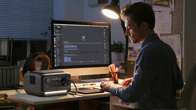 Man using EcoFlow River 3 Plus Wireless Boost Combo while working on computer