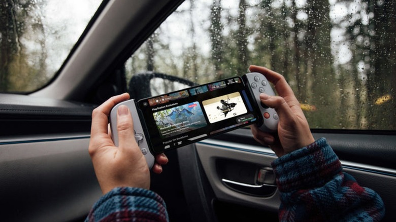 Person using PS Remote Play on smartphone with Backbone One PlayStation Edition while in car