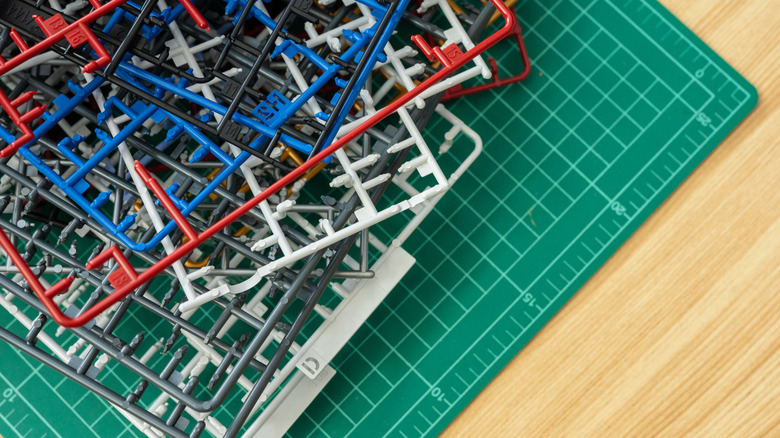 Toy model kit frames on a workbench with parts removed.