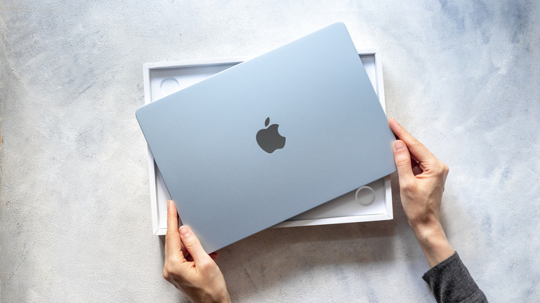 Person unboxing a MacBook