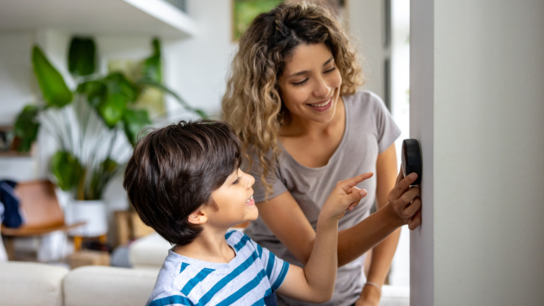 A mother and child using a smart home device together.