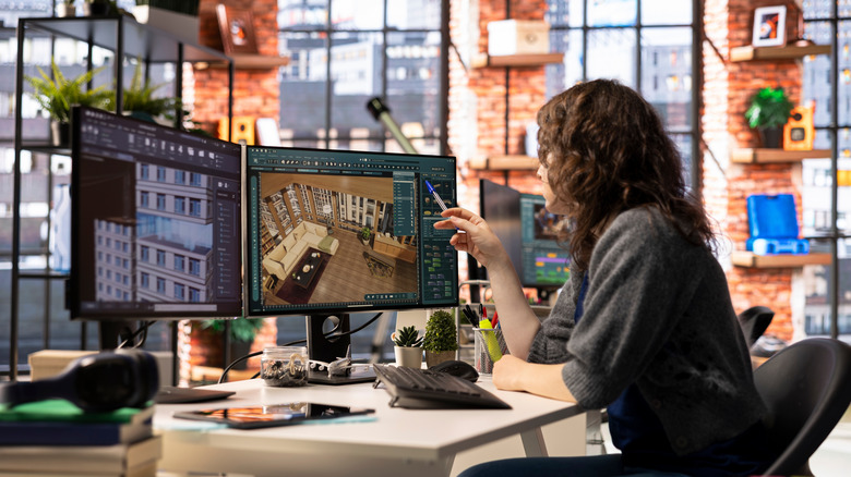 A digital designer working on dual monitors.