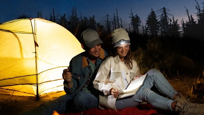 Lepro Headlamp in use by couple while camping outdoors, to read in the dark.