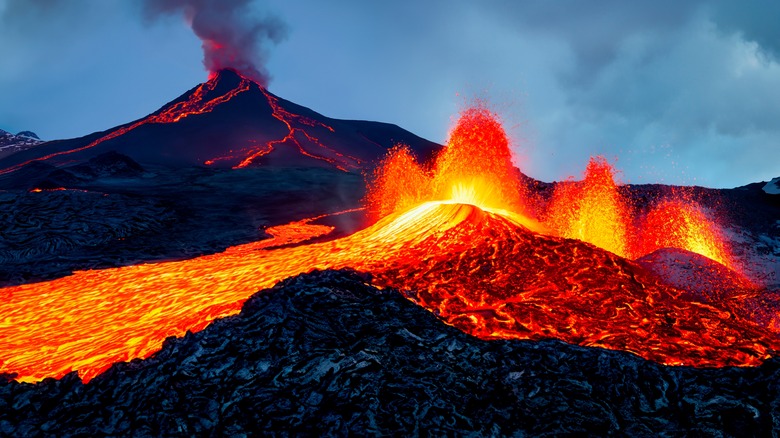 Volcano spewing smoke as lava flows