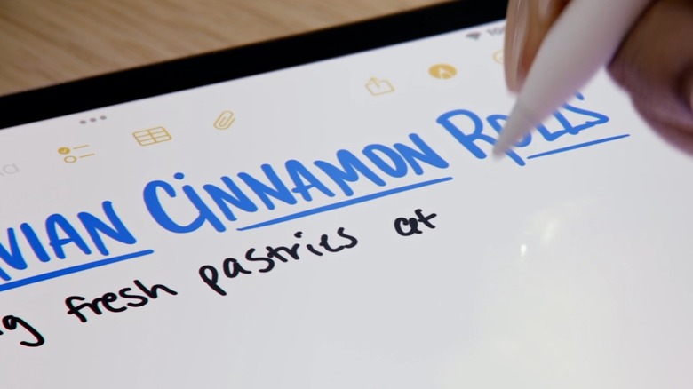 A woman writing on an iPad display