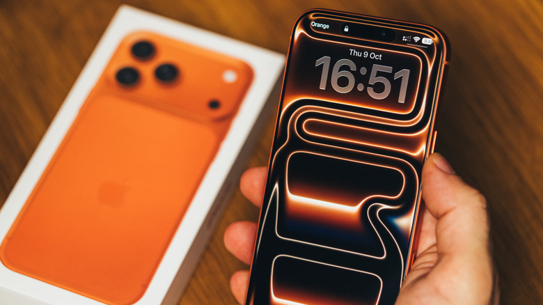 Person holding an iPhone 17 Pro Max in Cosmic Orange