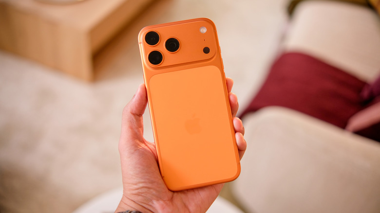 An iPhone 17 Pro in Cosmic Orange with its camera setup showing