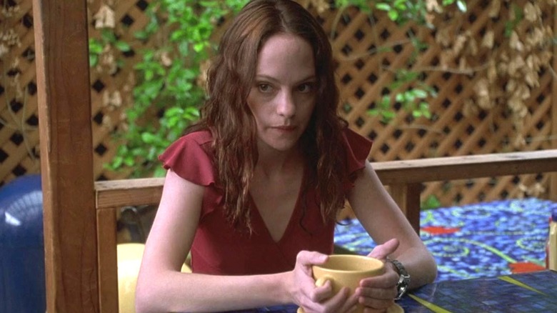 May holding a mug while sitting at a table in "May."