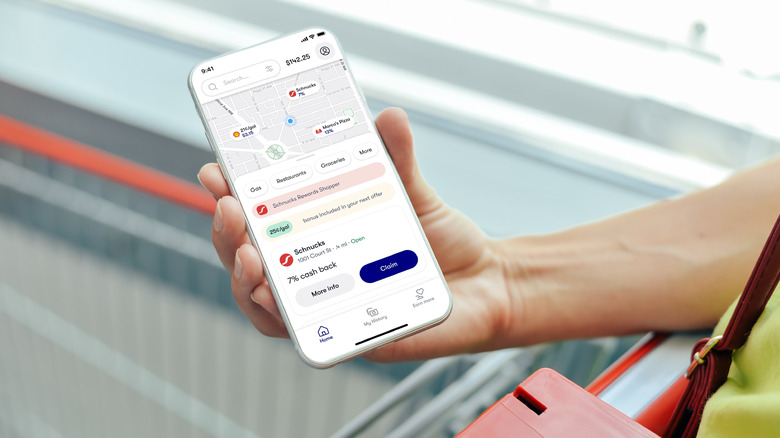 A person holding a smartphone with Upside app on the screen