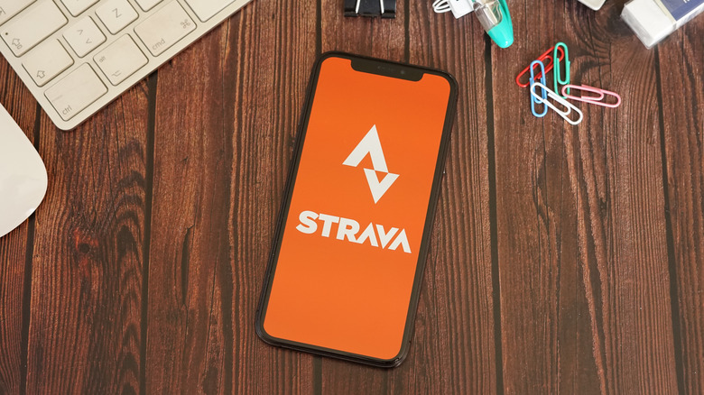 Strava app on an iPhone that is lying on dark wood