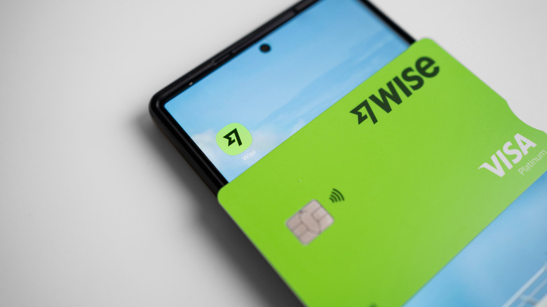 Wise debit card on top of mobile phone with app icon visible.