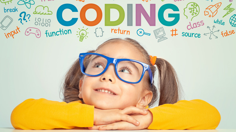 Girl with glasses looking at colorful coding word