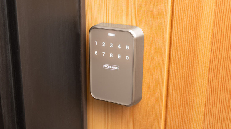 Schlage smart lock keypad mounted on a wooden door.