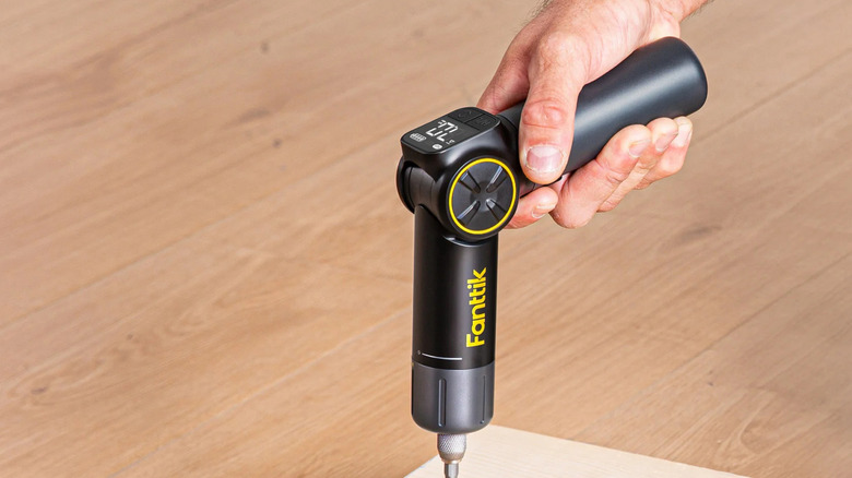 Drilling into a board with a Fanttik Electric Screwdriver.