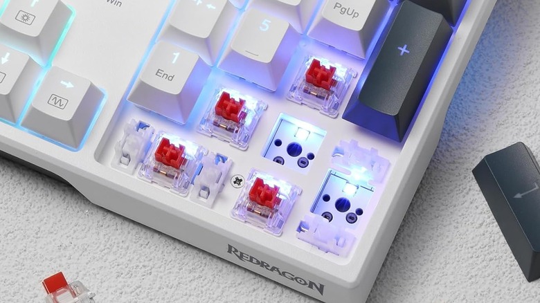 A Redragon K668 RGB Gaming Keyboard with several key caps and switches removed.