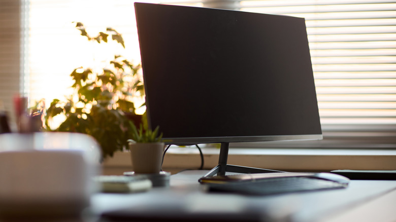 Close up view of modern desktop workspace with monitor and other gear.