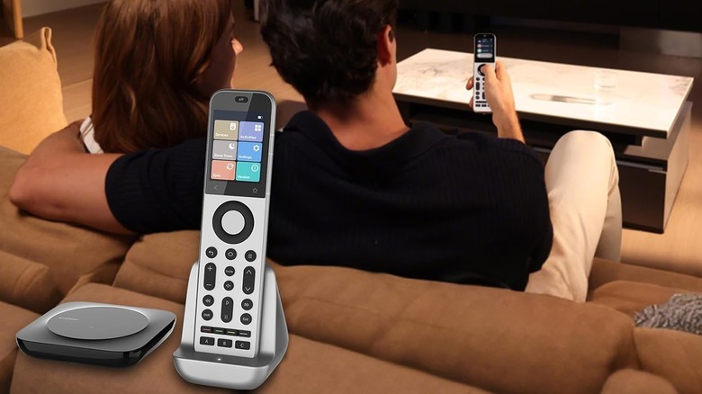 A couple uses a SofaBaton X2 universal remote while sitting on a couch.