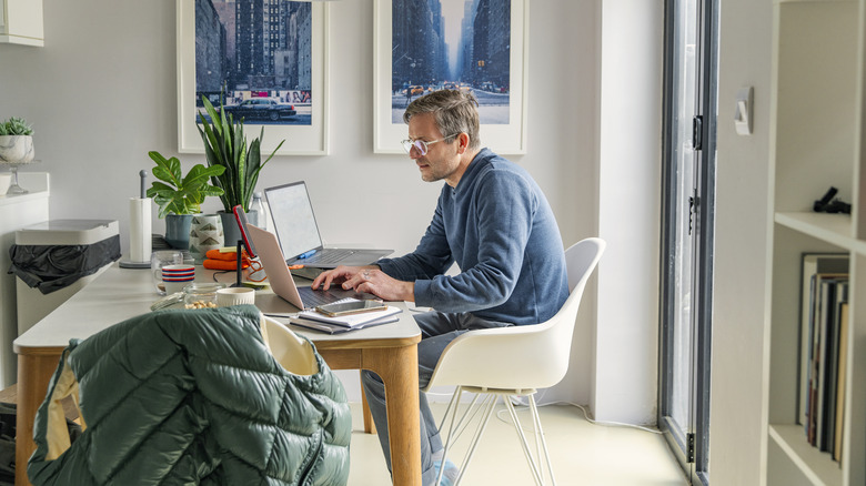 A man working on a laptop in a home office.