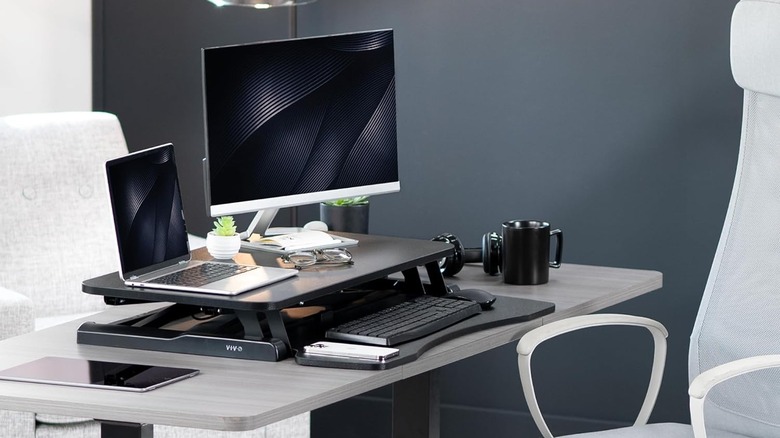 The VIVO K-Series Height Adjustable Sit to Stand Riser set up on a computer desk.