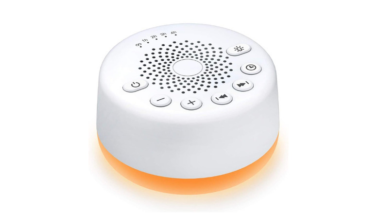 close up of a hand holding a white noise machine