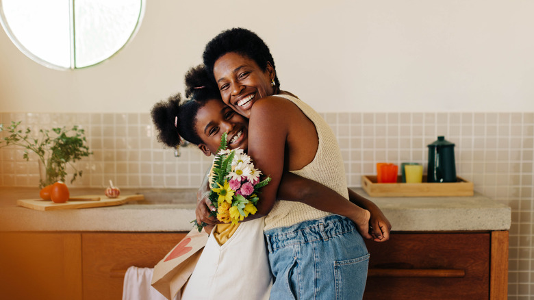 A mother hugging her daughter.