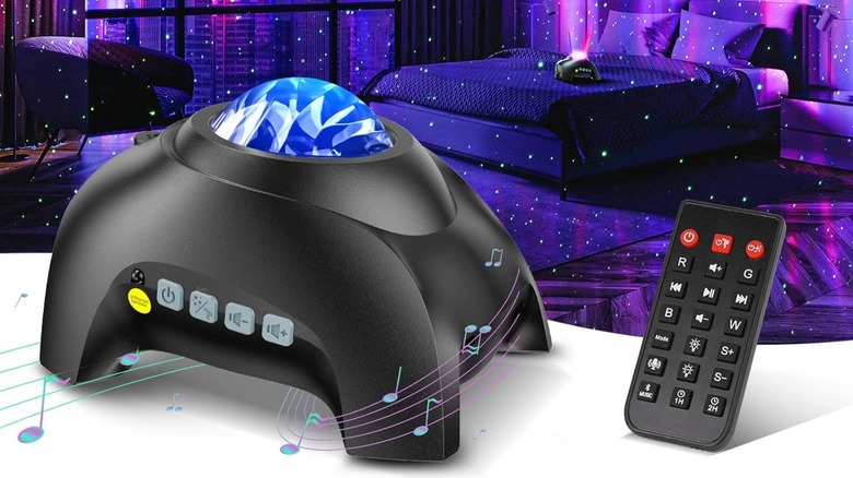 A photo of the Hodans Northern Galaxy Light Aurora Projector and its remote, behind the objects is a bedroom displaying how the lights interact with a room