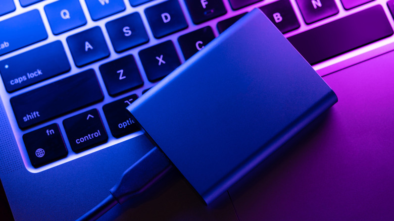 An SSD connected to Macbook under neon lights