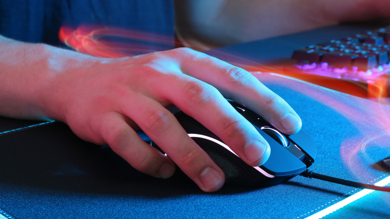 A hand holding a gaming mouse, with blurred lines showing movement