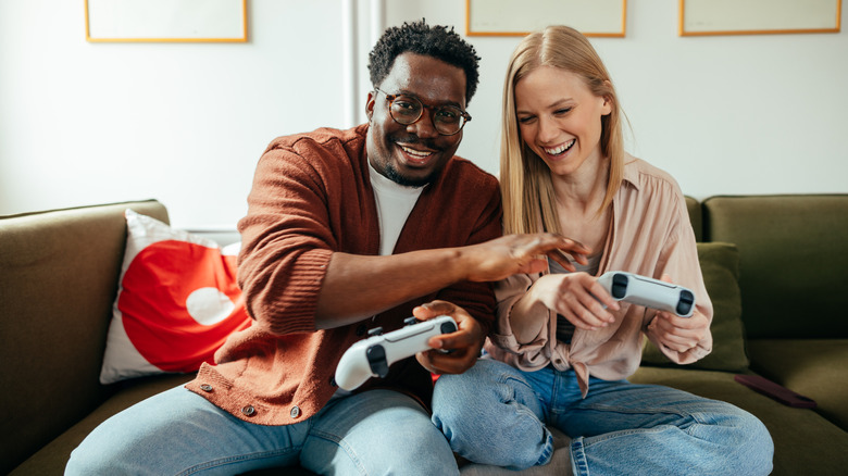 A couple holding PS5 controllers