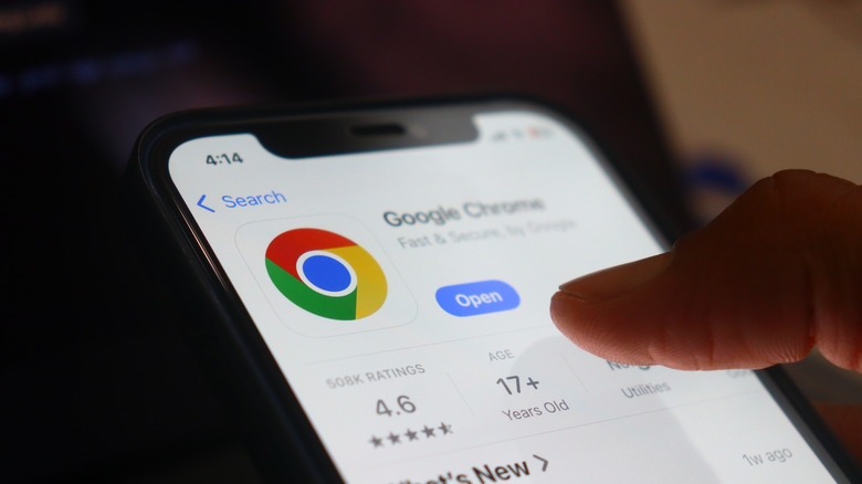 Hand holding an iPhone showing Google Chrome App Store listing page