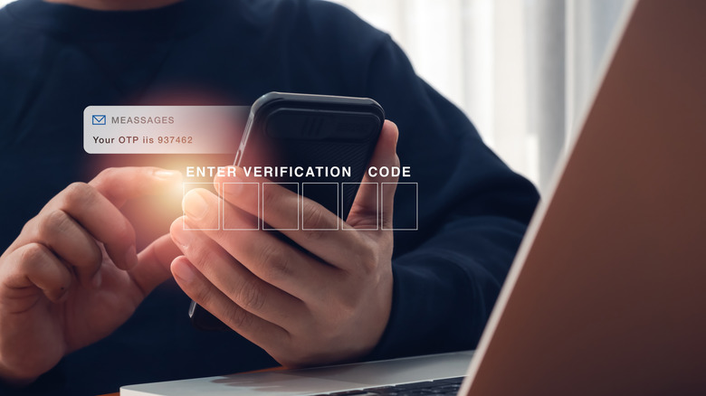 a person entering a verification code from messages into a laptop