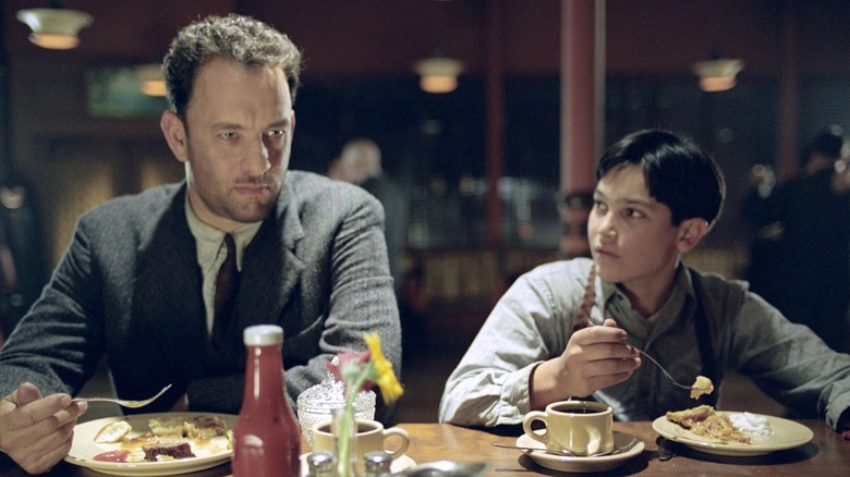 Tom Hanks and Tyler Hoechlin as Michael Sullivan Sr. and Michael Sullivan Jr. eating in Road to Perdition (2002)