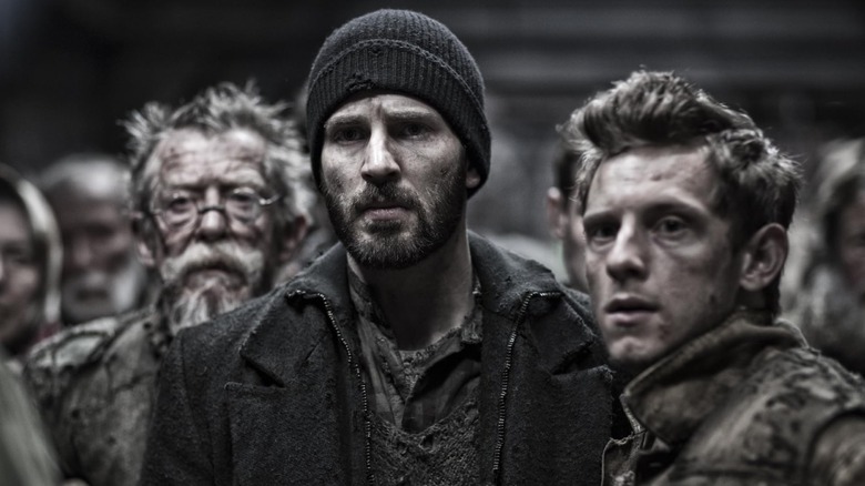 Gilliam (John Hurt), Curtis (Chris Evans), and Edgar (Jamie Bell) standing together on Snowpiercer